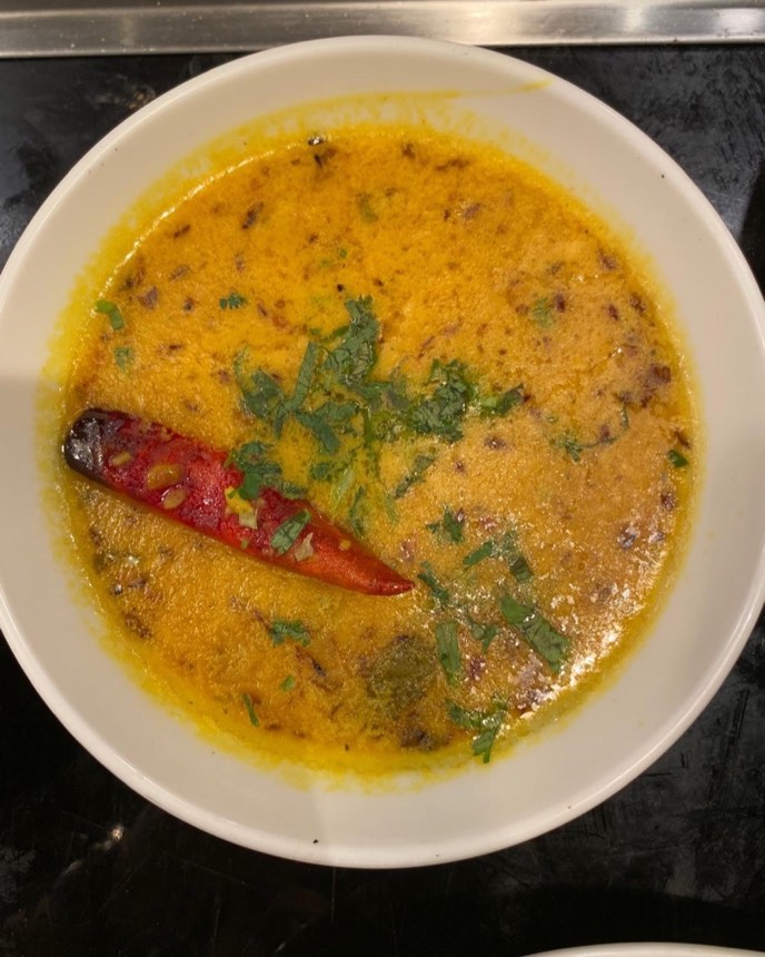 Slow-cooked black dal with a whole red chilli